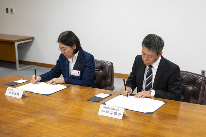 協定書にサインする伊東市長と戸井代表理事