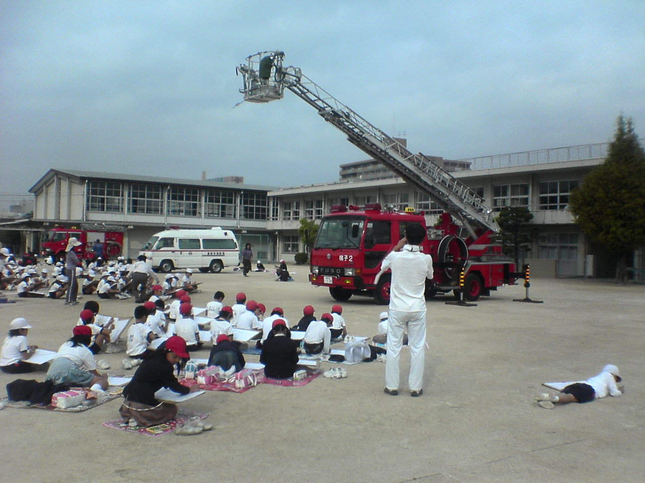 小学生による消防車写生大会の写真　梯子車等を写生している